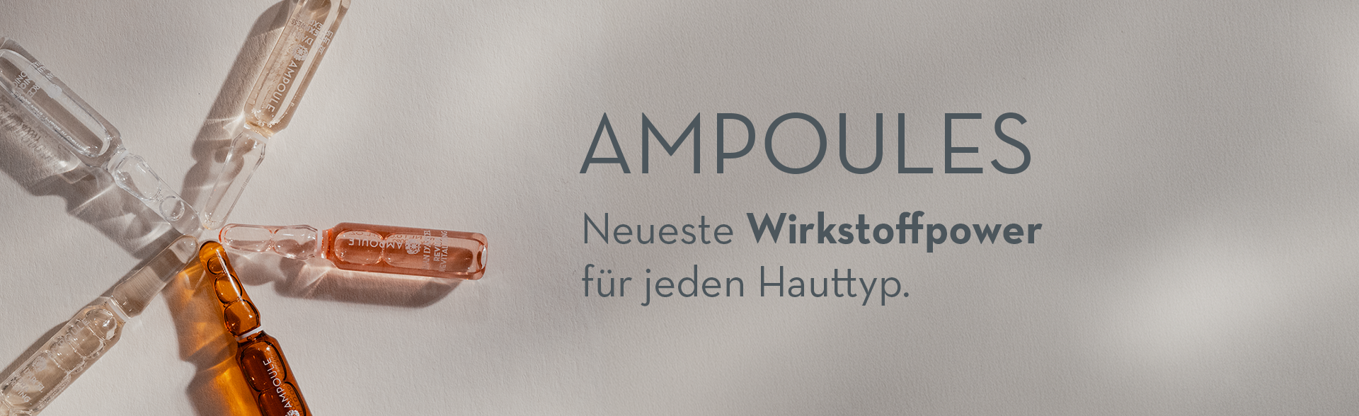 Mehrere Jean D'Arcel Ampullen liegen fächerförmig auf hellem Untergrund. Daneben der Schriftzug „AMPOULES – Neueste Wirkstoffpower für jeden Hauttyp.“
